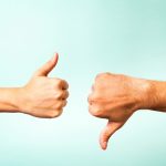Two hands signalling thumbs up and thumbs down